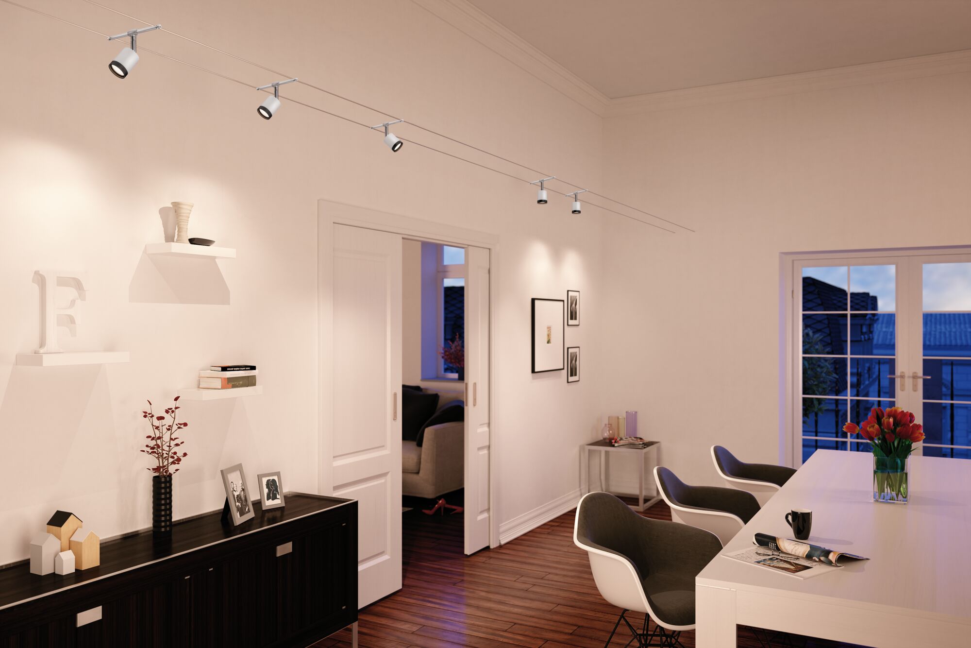 Moderner weißer Seilstrahler mit fünf Spots in elegantem Wohnzimmer mit Holzboden und weißen Möbeln