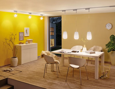 Moderne eetkamer met witte stoelen, tafel en warmwitte LED-hanglampen aan railsysteem