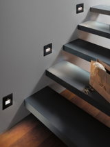 Moderne schwarze LED-Treppenbeleuchtung in Wandmontage mit warmweißem Licht und Bewegungssensor.