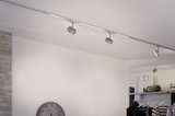 Éclairage sur rail LED argenté moderne avec spots réglables dans une pièce minimaliste.
