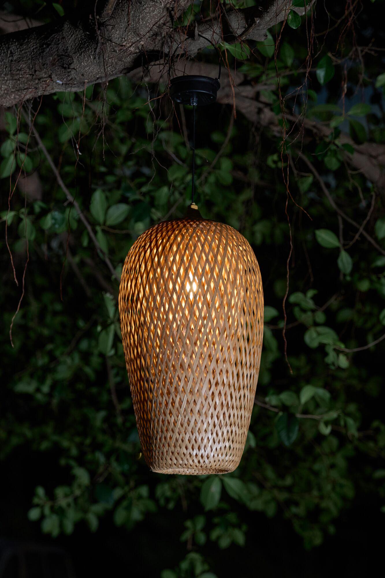 Hanging lamp made of woven natural material in brown with warm light for garden lighting