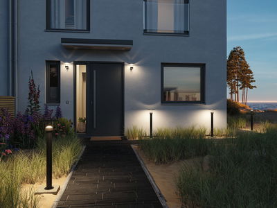 Modern outdoor lighting with black LED path lights and wall lamps at house with dark door.
