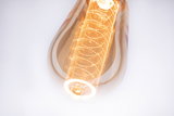 Close-up van warmwitte LED-lamp met decoratief filament en amberkleurig glas voor sfeerverlichting