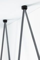 Supports de plafond noirs avec sangles textiles grises pour suspensions LED modernes en intérieur.