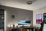 Moderne kantoorruimte met zwarte ronde LED-plafondlamp die warm wit licht geeft boven gaming bureau