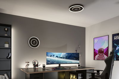 Moderne kantoorruimte met zwarte ronde LED-plafondlamp die warm wit licht geeft boven gaming bureau