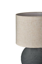 Table lamp with beige fabric shade and dark grey textured ceramic base for home lighting
