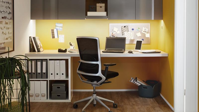 Modern office with ergonomic black desk chair and yellow LED task lighting for productive workspace setup