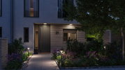 Modern outdoor lighting with warm white LED bollard lights and ceiling lights at entrance with garden path.