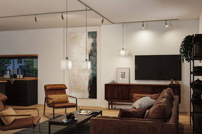 Modern living room with brown leather furniture and white Paulmann pendant lights for warm ambient lighting