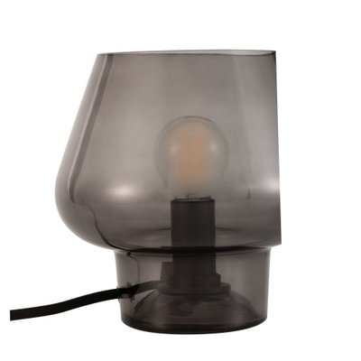 Modern table lamp made of smoked glass with visible bulb and black cable for living spaces