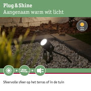 Zwarte buitenspot met warm wit licht op kiezelstenen voor tuinverlichting