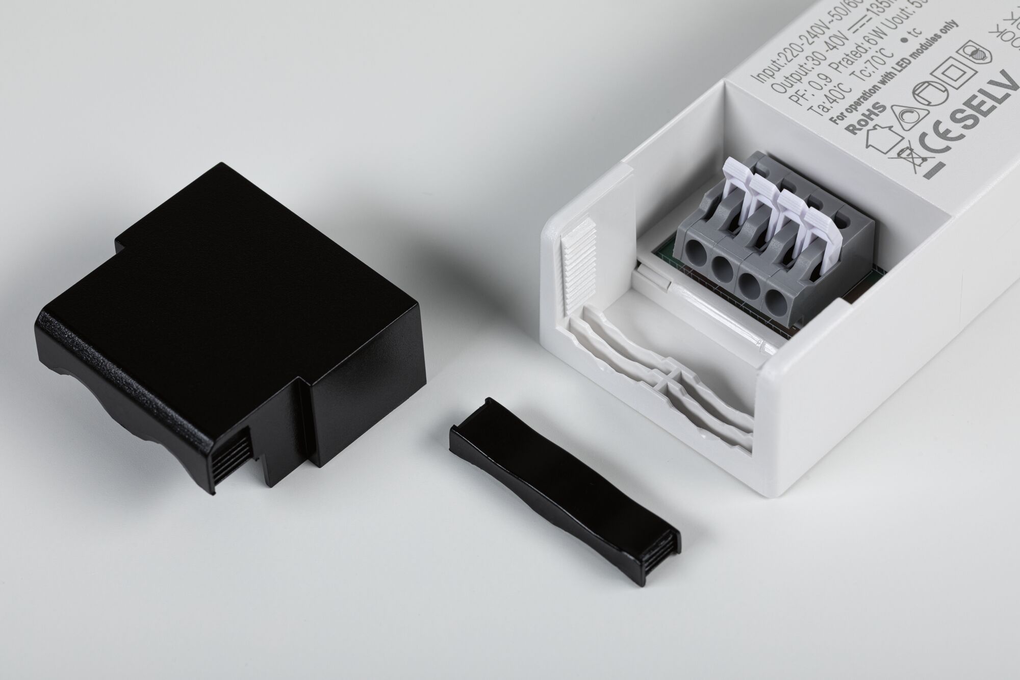 White LED power supply with open terminal block and removed black plastic cover and clamp strip