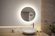 Runder beleuchteter Badspiegel mit warmweißem LED-Ring über weißem Waschbecken und Holzplatte