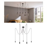 Moderne schwarze Pendelleuchte mit fünf Kabeln und Glühbirnen in Wohnzimmer mit grauer Wand.