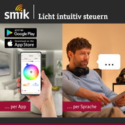 Mann steuert Lichtfarbe per App auf Smartphone und Sprachbefehl im modernen Wohnzimmer