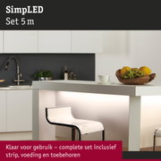 Moderne witte keukenbar met verlicht aanrecht en transparante barkruk in minimalistisch design