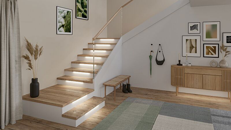 Modern living area with wooden staircase featuring integrated LED step lighting for ambient illumination