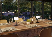 Table à manger en bois moderne avec deux petites lampes LED noires sur table dans une salle à manger chaleureuse.