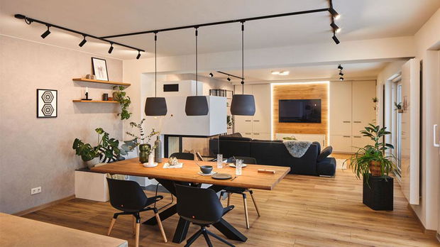 Moderne woonkamer met houten eettafel, zwarte stoelen en Paulmann LED-plafondspots voor kamerlicht.