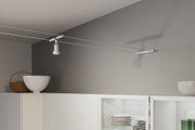 Weißer Seilstrahler aus Metall an grauer Wand montiert für moderne Küchenbeleuchtung