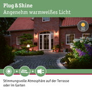 Rotes Backsteinhaus mit warmweiß beleuchteter Terrasse und Gartenbeleuchtung für Außenbereich