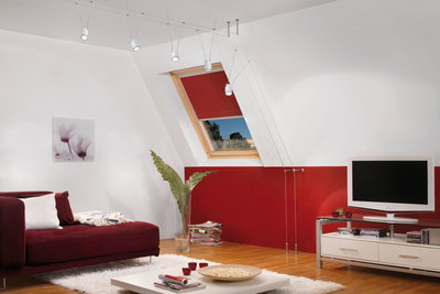Modern living room with red sofa, white rug, white cable suspension ceiling lights and wooden floor