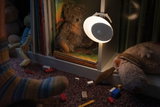 Lampe de nuit LED blanche avec détecteur de mouvement sur étagère blanche près de peluches et livres d'enfants.