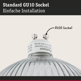 Nahaufnahme eines GU10 Sockels aus weißem Kunststoff mit Glasreflektor für LED-Lampen