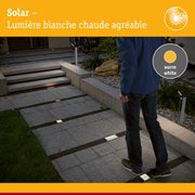 Éclairages solaires encastrés au sol avec lumière blanc chaud sur pavé gris extérieur