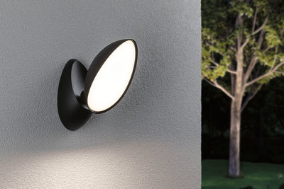 Schwarze LED-Wandleuchte mit ovalem, weißem Leuchtpanel an grauer Außenwand für Gartenbeleuchtung