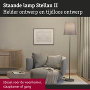 Staande lamp Stellan II met grijze stoffen kap en metalen voet in moderne woonkamer