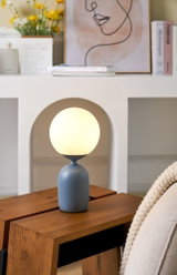 Modern table lamp with matte blue metal base and round white glass light for living room lighting
