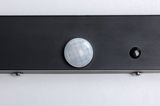 Nahaufnahme eines schwarzen Sensors mit weißer, facettierter Linse auf grauem Hintergrund für Lichtsteuerung