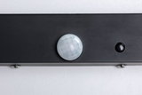 Close-up of black sensor with white faceted lens on gray background for light control technology