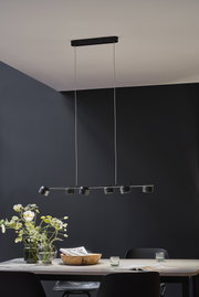 Zwarte LED-plafondlamp met zes verstelbare spots boven moderne eettafel met decoratie