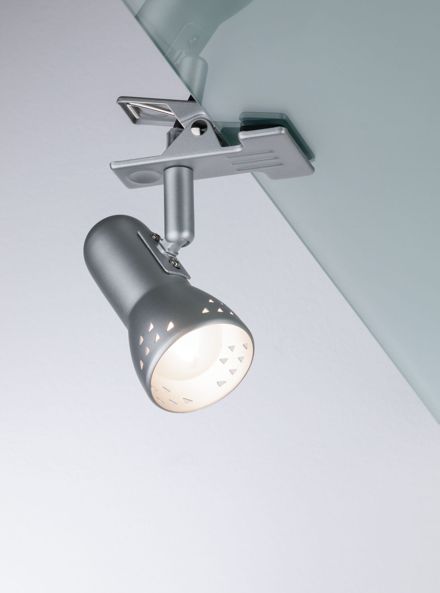 Silberner LED-Spot aus Metall mit Clip-Halterung an Glasplatte für flexible Beleuchtung.