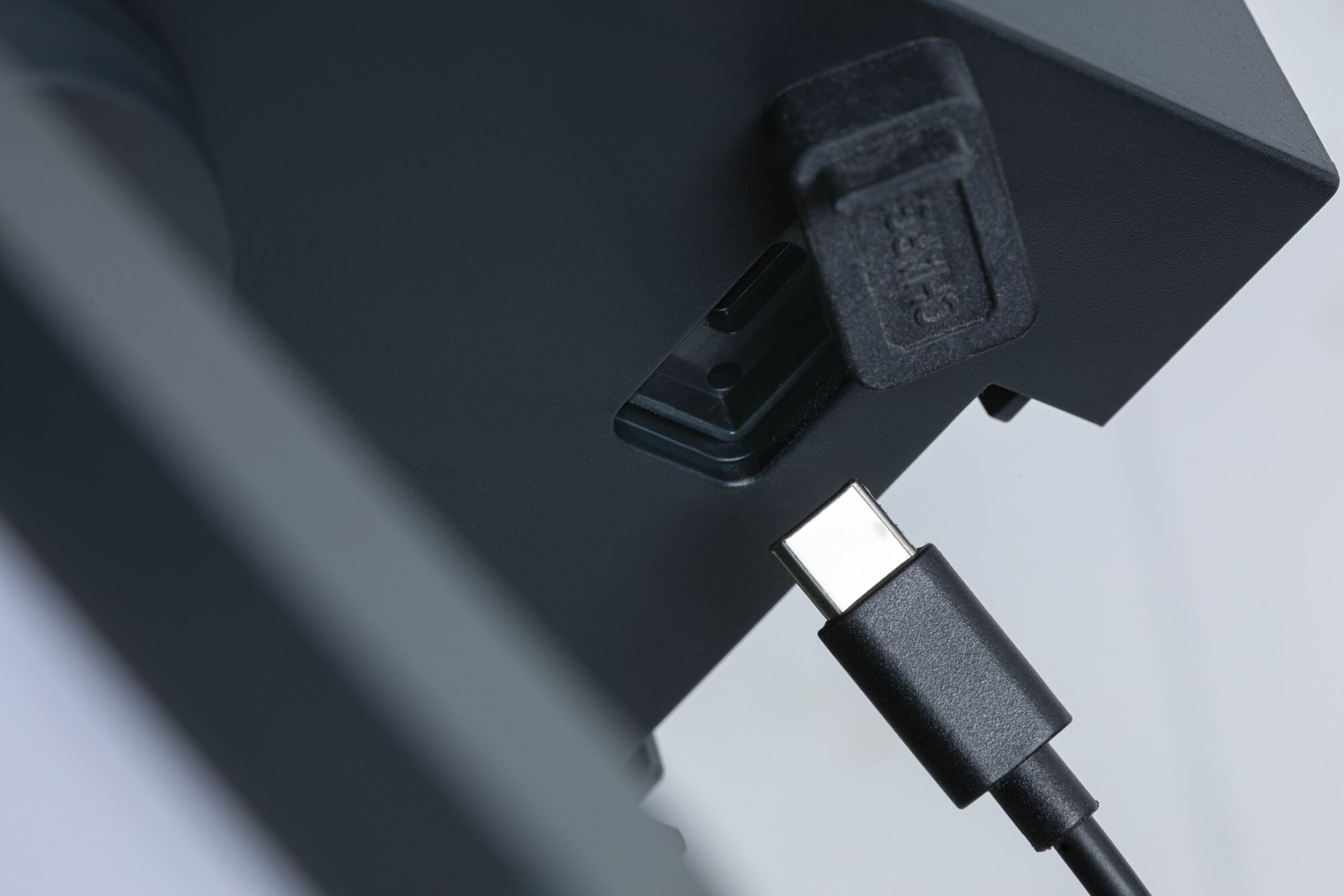 Close-up of a black USB-C cable about to connect to a black device port