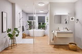 Modern bathroom with white bathtub, glass shower, wooden floor, and LED ceiling lights