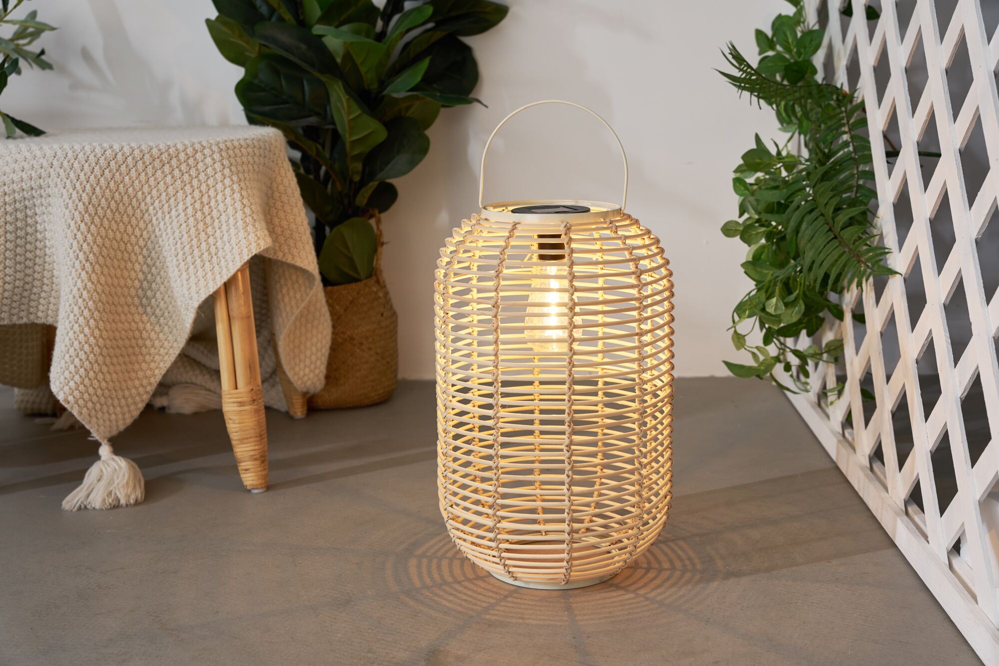 Beleuchteter runder Lampion aus hellem Rattan mit Griff für stimmungsvolle Dekoration und LED Licht.