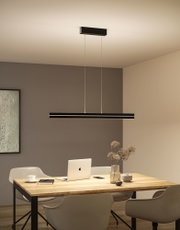 Schwarze LED-Pendelleuchte aus Metall über hellem Holztisch mit Laptop und Deko im modernen Esszimmer