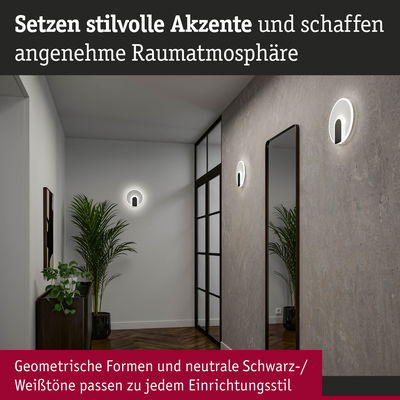 Moderne Wandlampen mit geometrischem Design in Schwarz-Weiß setzen stilvolle Akzente im Flur mit Spiegel und Pflanzen