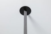 Fixation de plafond ronde noire avec câble textile gris pour suspension LED moderne.