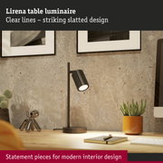 Black Lirena table lamp with ribbed shade on wooden desk with decor and notebook for modern interiors