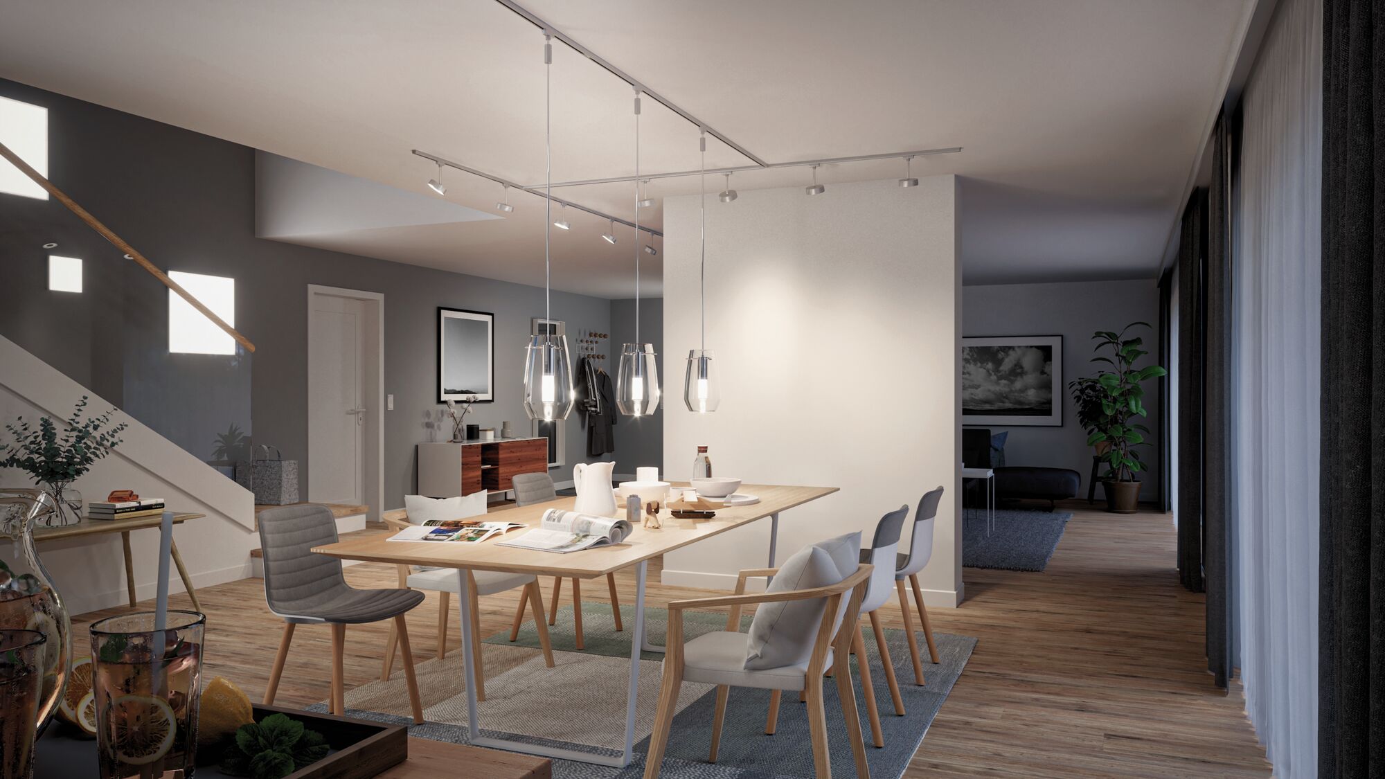 Modern dining area with wooden chairs and table lit by clear Paulmann glass pendant lights.