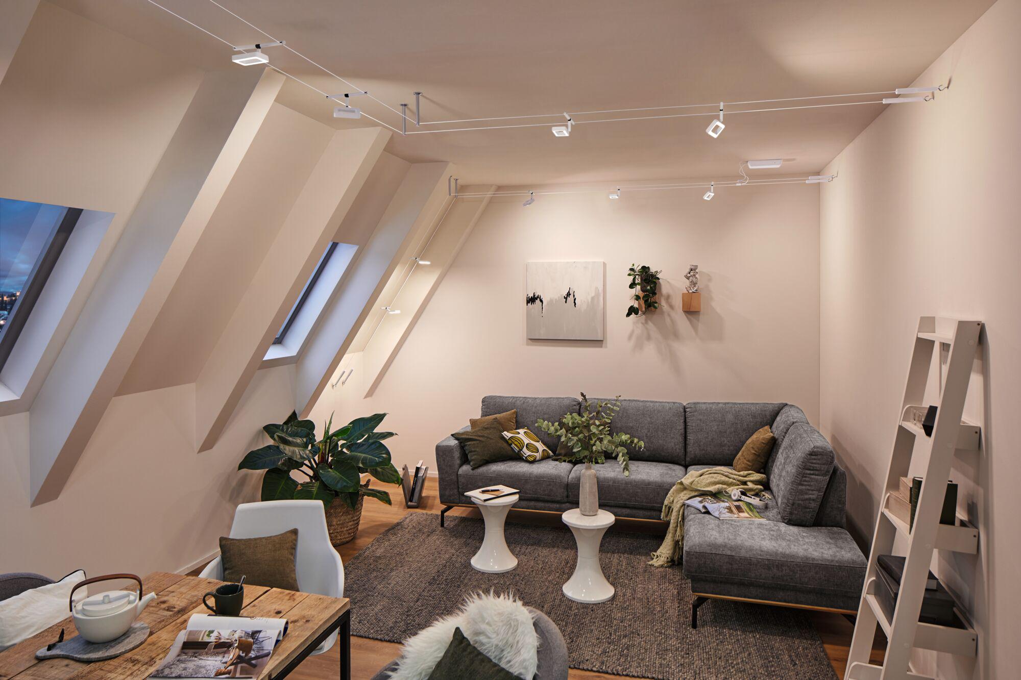 Modern living room with grey fabric sofa, white LED cable spotlights and wooden flooring