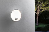 Round white outdoor wall light with motion sensor on grey wall for garden lighting.