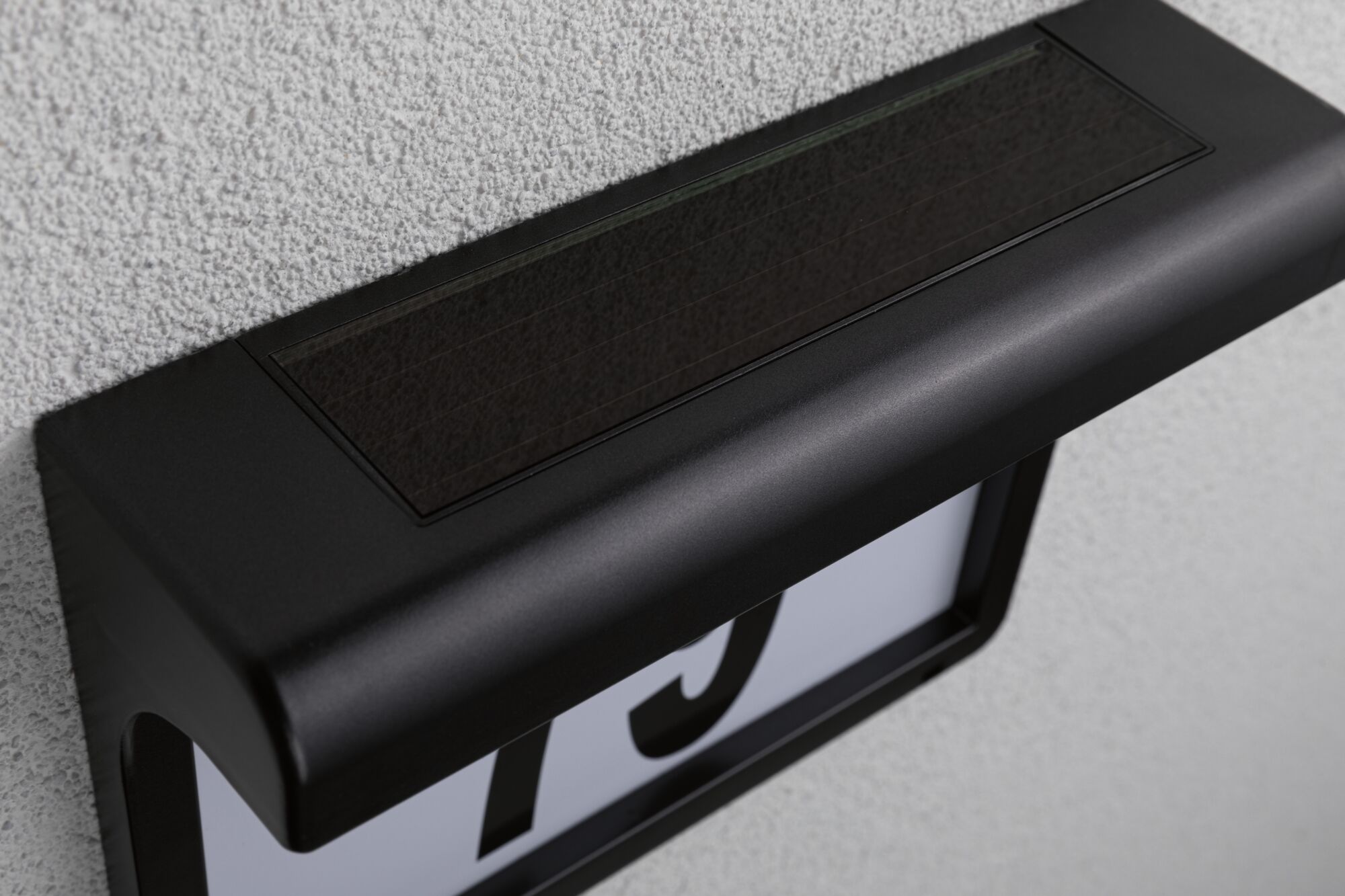 Black metal house number sign with integrated solar panel for outdoor use