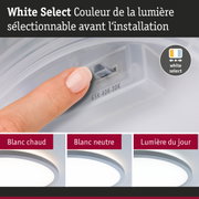Doigt réglant la couleur de lumière sur un interrupteur blanc avec trois options LED