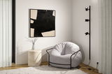 Cozy grey armchair with black metal frame beside modern black wall lamp with three spotlights